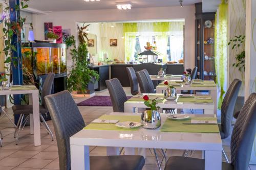 a dining room with tables and chairs in a restaurant at Hotel Rosengarten in Schwäbisch Gmünd