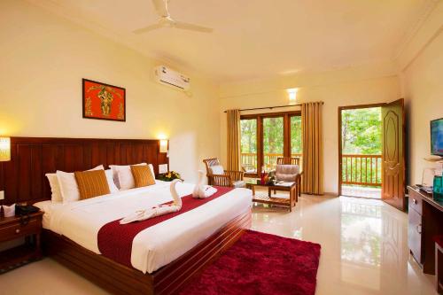 ein Schlafzimmer mit einem großen Bett mit einem roten Teppich in der Unterkunft Coffee Routes in Thekkady