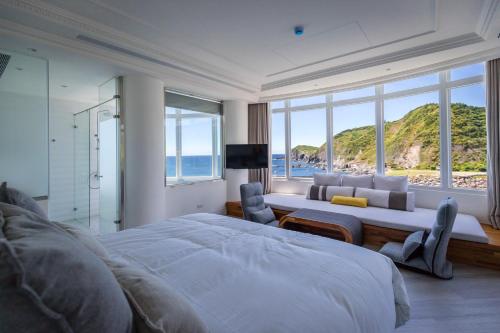a bedroom with a large bed and a view of the ocean at Brighthouse in Suao