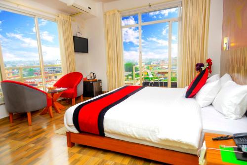 a bedroom with a bed and a large window at Hotel City Inn - Mountain View in Pokhara