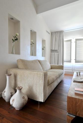 a living room with a couch and two vases on the floor at La Maison d'Aix 1785 - Hôtel Particulier & Spa in Aix-en-Provence