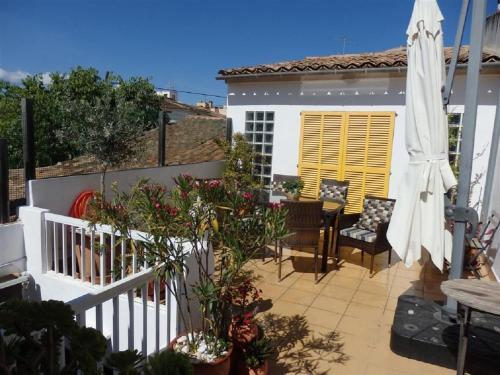 a patio with a table and chairs and an umbrella at Can Tassi in Porto Cristo