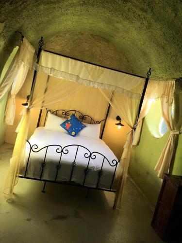a bedroom with a canopy bed with white sheets and pillows at Kenting Ha-Bi Star Fort in Hengchun