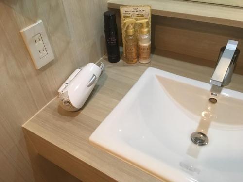 N hotel #NL1 في شيبا: حوض الحمام مع فأر الكمبيوتر على منضدة
