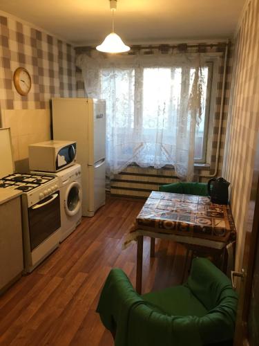 モスクワにあるApartment G-Kvartal at Tushinskayaのキッチン(コンロ、冷蔵庫、テーブル付)