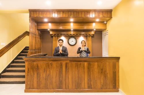 a man and a woman standing behind a wooden podium at Hotel Lake Shore in Pokhara