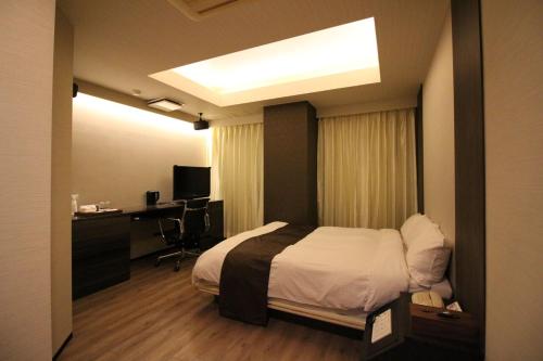 N hotel #NL1 في شيبا: غرفه فندقيه بسرير ومكتب ونافذه