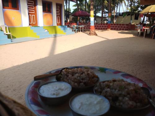 a plate with two bowls of food on a table at Hotel Rosary House in Malvan
