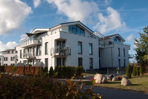 a white building with a lot of windows at Haus Calmsailing in Börgerende-Rethwisch