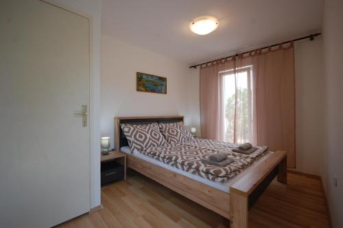 a bedroom with a bed and a window at Holiday home Darinka in Bajčići