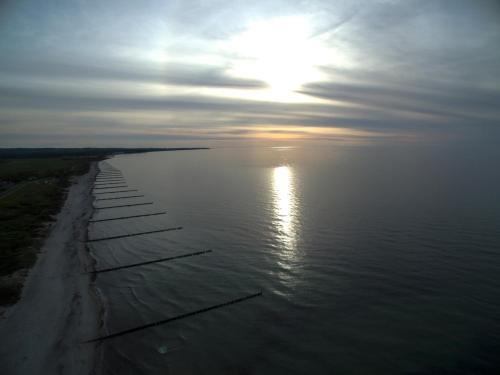 a large body of water with the sun in the sky at Haus Calmsailing in Börgerende-Rethwisch