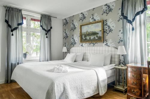 Dömle Herrgård Spa & Resort في Deje: غرفة نوم مع سرير أبيض وورق جدران زرقاء