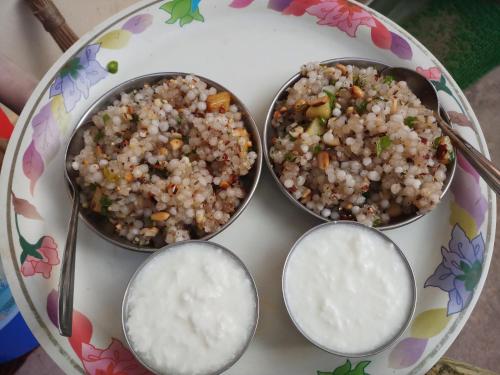 three bowls of food on a plate with rice at Hotel Rosary House in Malvan