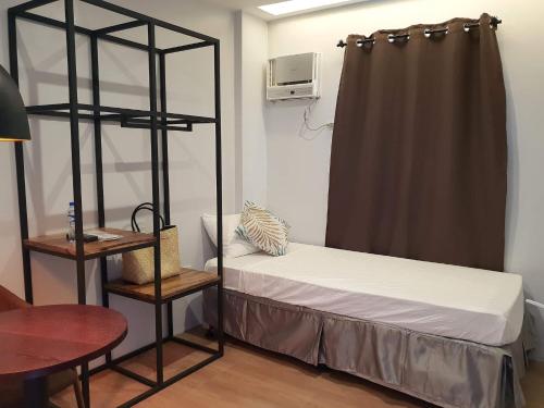 a bedroom with a bunk bed and a table and a desk at Balar Hotel and Spa in Boac