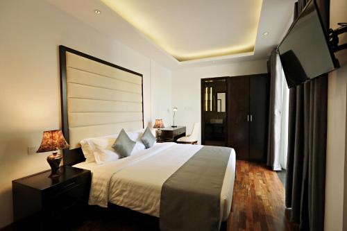a bedroom with a large bed and a flat screen tv at Lavonca Boutique Hotel in Colombo