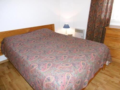 a bed in a room with a bedspread on it at Appartment Erwan in Arzon