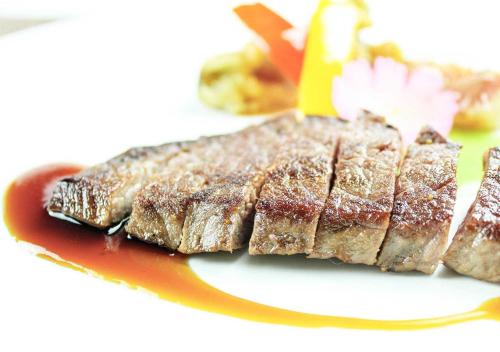 a piece of meat on a plate with a fork at Aura Tachibana in Hakone