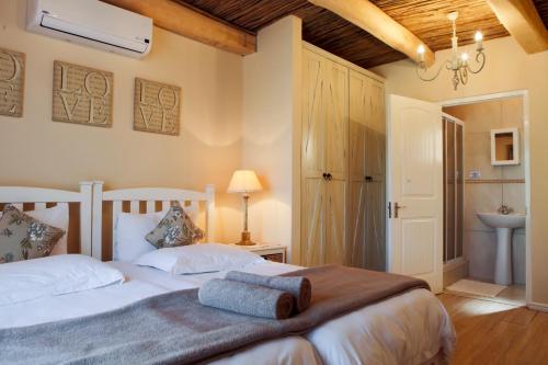 1 dormitorio con 1 cama y lavamanos. en Skilpadvlei Wine Farm, en Stellenbosch