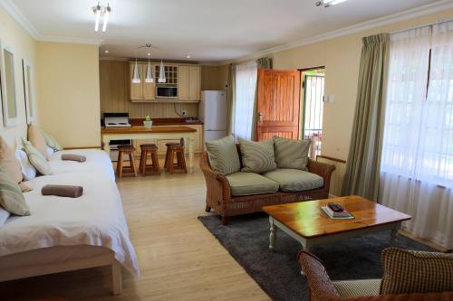 Sala de estar con cama, sofá y mesa en Skilpadvlei Wine Farm, en Stellenbosch