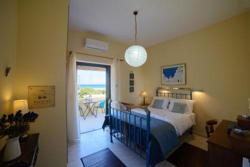 シダリにあるEleonora Sidari Beach Houseのベッドルーム1室(ベッド1台付)、パティオへのドアが備わります。