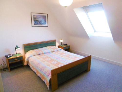 une chambre avec un lit avec deux tables de nuit et une fenêtre dans l'établissement Appartement Iffic, à Sarzeau