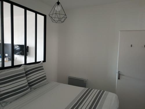 um quarto com uma cama e uma cabeceira em preto e branco em Sweet home em Dijon