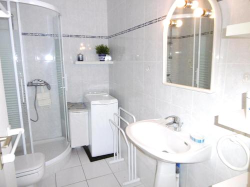 une salle de bain blanche avec un lavabo et une douche dans l'établissement Appartement Iffic, à Sarzeau