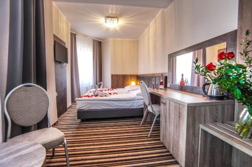 a hotel room with a bed and a table and chairs at New Corner in Niechorze