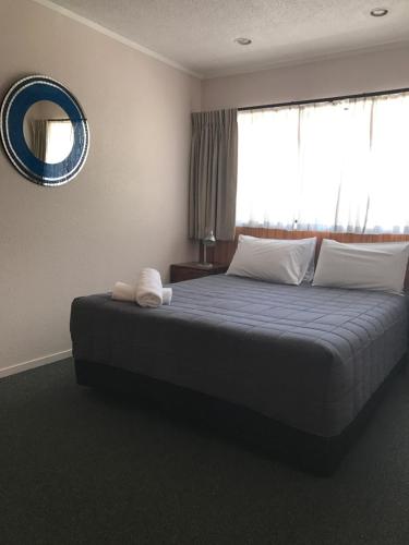 a bedroom with a large bed with a large window at Edelweiss Motel in Paihia
