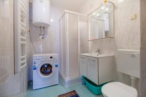 ein Badezimmer mit Waschmaschine und Waschbecken in der Unterkunft Apartment Simpatico in Čunski