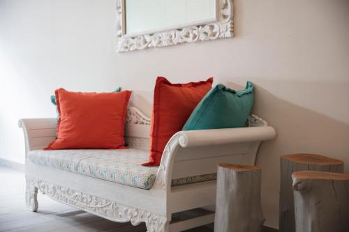 a bench with colorful pillows on it in a room at The Bay in Rivière Noire