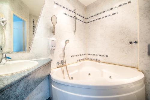 y baño con bañera y lavamanos. en Art Hotel Charlottenburger Hof Berlin, en Berlín