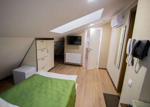 a small room with a bed and a television at Hotel Villa Natali in Chişinău