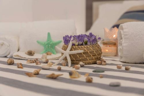 a table with a basket of flowers and shells at MareinSicilia: Talia Residence in Sampieri