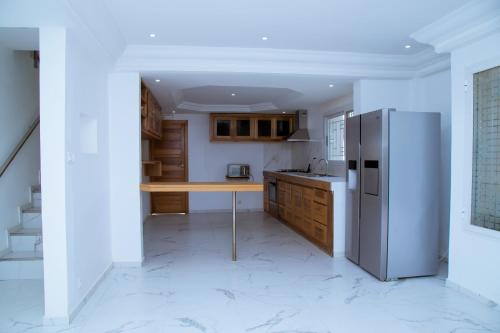 eine Küche mit einem Kühlschrank und einem Tisch darin in der Unterkunft Villa Somone pied dans l’eau in Somone