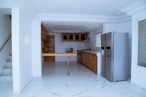 a kitchen with a refrigerator and a table in it at Villa Somone pied dans l’eau in Somone