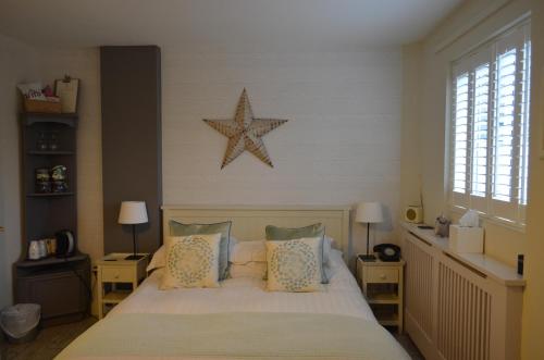 a bedroom with a bed with a star on the wall at The Beach House in West Wittering