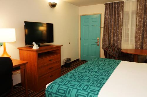 a hotel room with a bed and a flat screen tv at Howard Johnson by Wyndham Salinas in Salinas