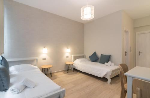 a room with two beds and two tables at Filoxenia Beach in Tsilivi