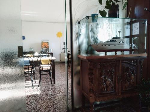 a dining room with a table with a boat in a glass case at Hostal Santa Gemma in Sant Vicenç de Montalt