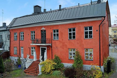 um edifício laranja com um telhado preto e escadas em Remuganes suite - Porvoon Linna em Porvoo
