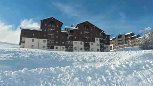 un grand bâtiment avec de la neige devant lui dans l'établissement Ski Sun 3315, à Manigod