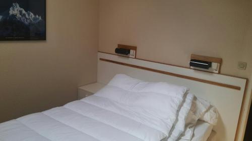 Schlafzimmer mit einem Bett mit weißer Bettwäsche in der Unterkunft Ski Sun 3315 in Manigod