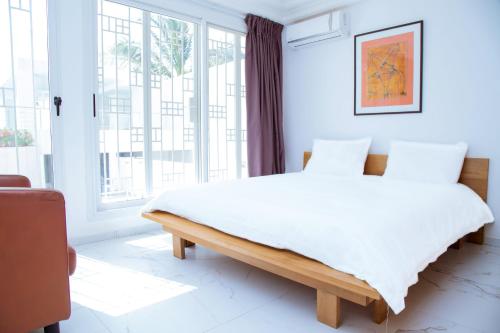 ein Schlafzimmer mit einem großen Bett und einem großen Fenster in der Unterkunft Villa Somone pied dans l’eau in Somone