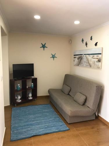 a living room with a couch and stars on the wall at CASAL RIQUEZO T2 - Serra da Pescaria - NAZARÉ in Nazaré