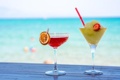 two cocktails sitting on a table next to the ocean at Filoxenia Beach in Tsilivi