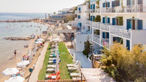a beach with umbrellas and people on the water at Filoxenia Beach in Tsilivi