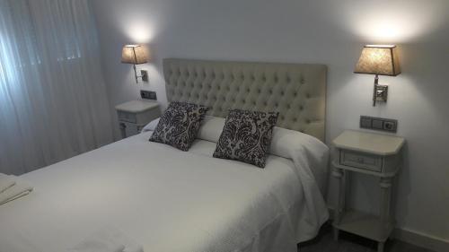 a bedroom with a white bed with two pillows on it at GUESTING VELAZQUEZ in Cádiz