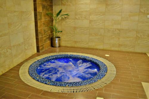 a blue bowl on the floor in a bathroom at Centaurus Hotel Suites in Islamabad