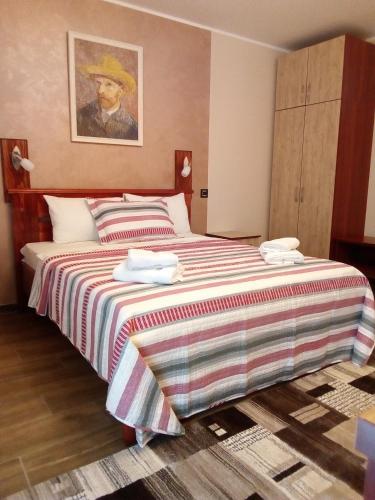 a bedroom with a large bed with a striped blanket at Konak Kutko in Pančevo